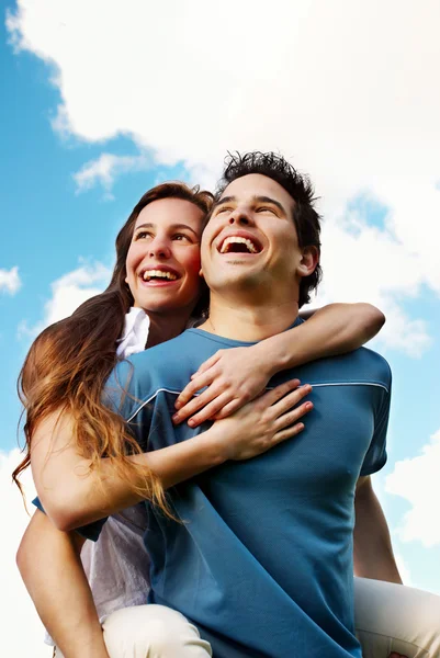 Jovem casal feliz contra o céu — Fotografia de Stock