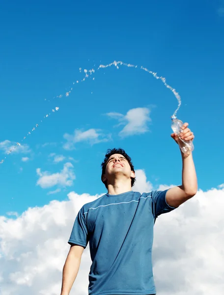 Junge mit Flaschenwasser gegen den Himmel — Stockfoto