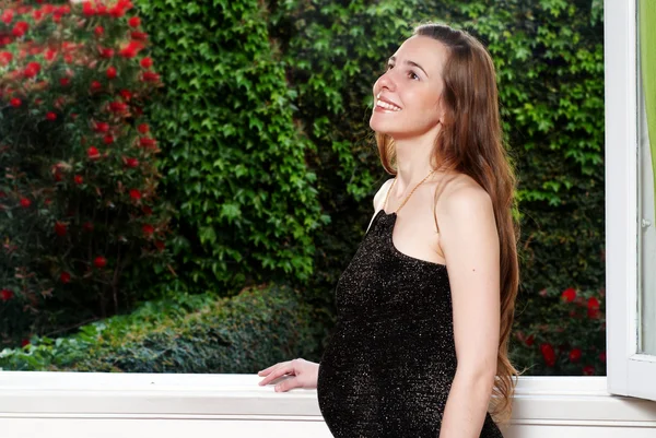 Terhes nő közelében egy ablak — Stock Fotó