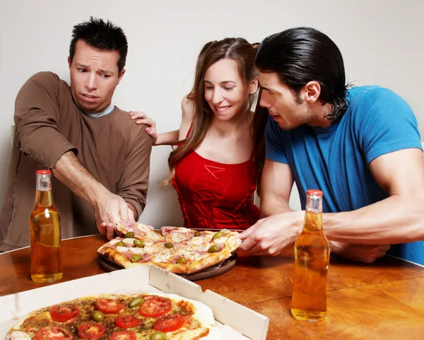 The cheerful company of youth eating a pizza — Stock Photo, Image
