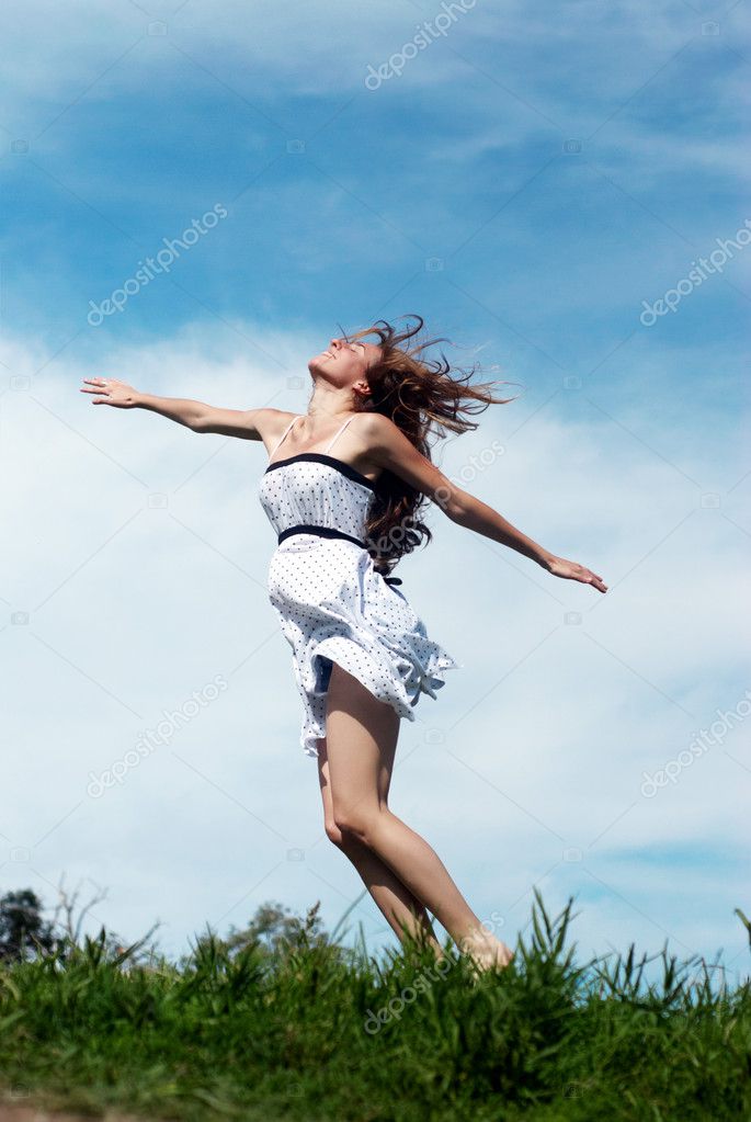 The girl running on a grass against sky