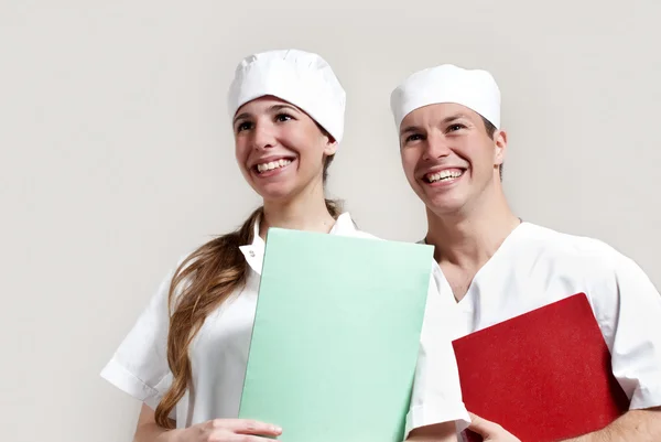 Portret van een gelukkige jonge arts en een verpleegster in het ziekenhuis — Stockfoto