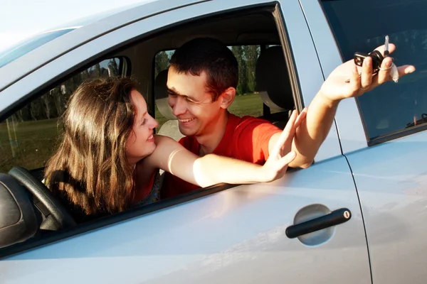 Happy young pair in just bought car — Stock Photo, Image