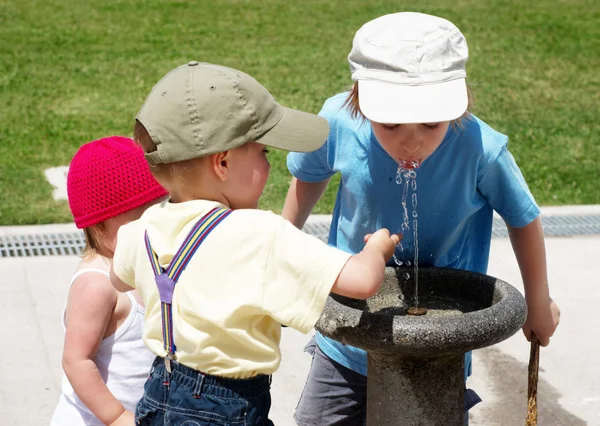 子供公園の飲料水の噴水に水を飲む — ストック写真
