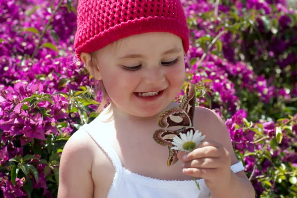 Маленькая девочка с бабочкой на природе — стоковое фото