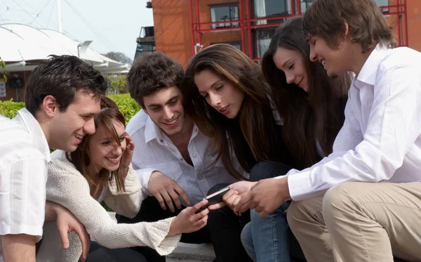 Feliz grupo joven en la calle con teléfono celular —  Fotos de Stock