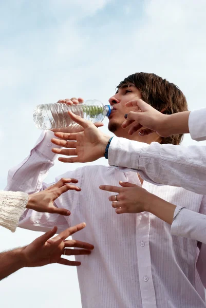 Молодые с бутылочной водой на фоне неба — стоковое фото