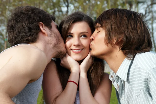 Glückliches Mädchen von zwei jungen Jungen geküsst — Stockfoto