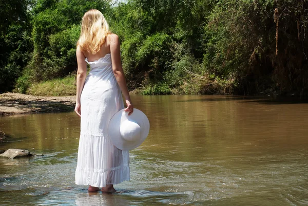 Mladá dívka v bílém děje řeky — Stock fotografie