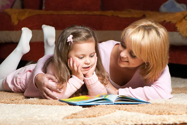 Doce menina com mãe leitura livro — Fotografia de Stock