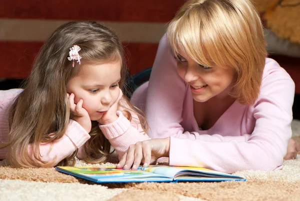 Douce petite fille avec mère lecture livre — Photo