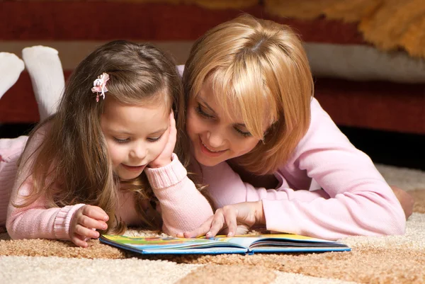 Doce menina com mãe leitura livro — Fotografia de Stock