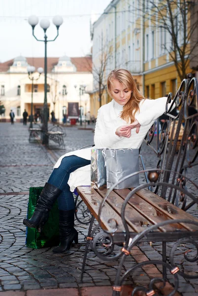 Fiatal nő ül egy padon — Stock Fotó
