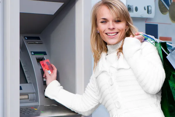 Жінка знімає гроші з кредитної картки в банкоматі. — стокове фото