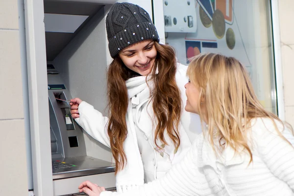 Glückliche Mädchen heben am Geldautomaten Geld von der Kreditkarte ab — Stockfoto