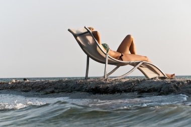 het meisje in een hoed met een rust op de zeekust