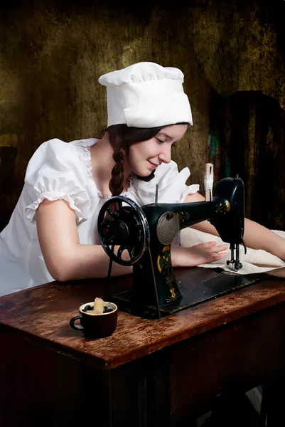 年轻的女裁缝与旧缝纫机的肖像 — 图库照片