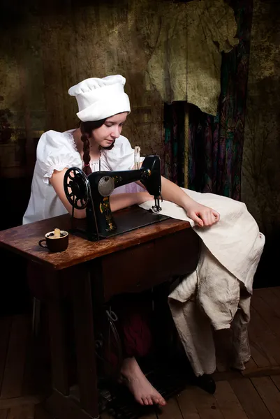 Portret van een jonge naaister met oude naaimachine — Stockfoto