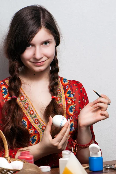 Egy fiatal lány, aki egy festmény egy tojás húsvéti portré — Stock Fotó