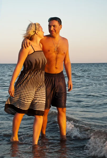 Lyckliga paret promenerar på stranden — Stockfoto