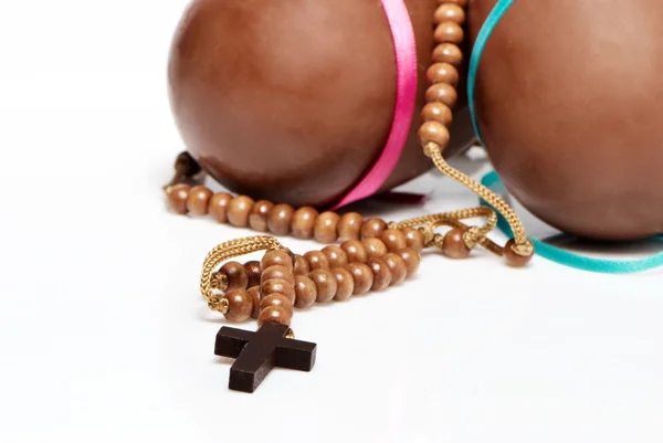Kříž nosí na krku na Velikonoční čokoládové vajíčka — Stock fotografie