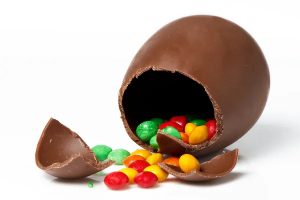 Pisanka czekoladowa i słodycze na jasnym tle — Zdjęcie stockowe