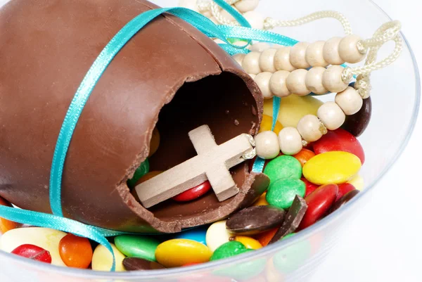 Huevo de chocolate de Pascua, dulces y cruz en un vaso — Foto de Stock