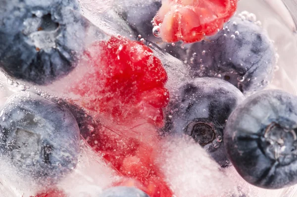 Framboises et mûres congelées dans des bâtonnets de glace — Photo