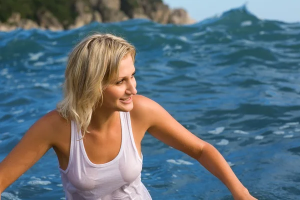 Молода жінка втікає з великої морської хвилі — стокове фото