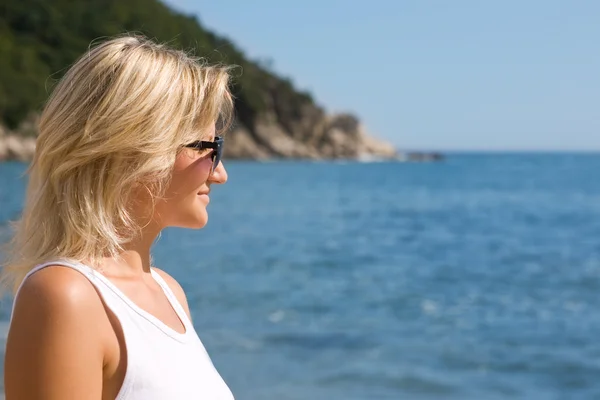 Glückliches Mädchen mit Sonnenbrille am Meer — Stockfoto