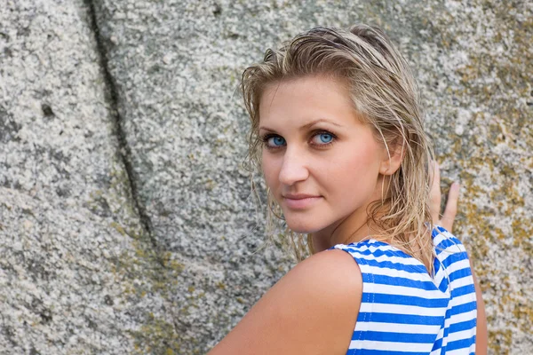Meisje met blauwe ogen op de achtergrond van rotsen — Stockfoto