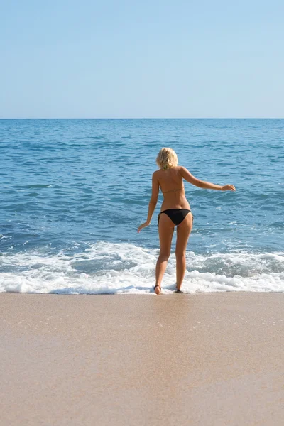 Meisje op het strand door zee. — Stockfoto