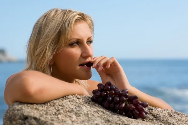 Stock image Beautiful girl eating grapes