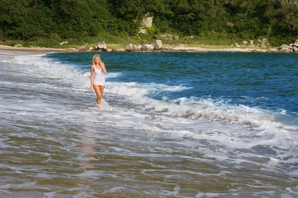 Jovem mulher vai à praia do mar — Fotografia de Stock