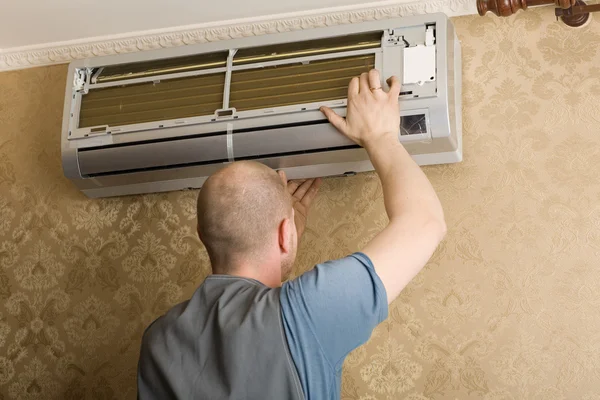 Technicien installe un nouveau climatiseur dans l'appartement — Photo