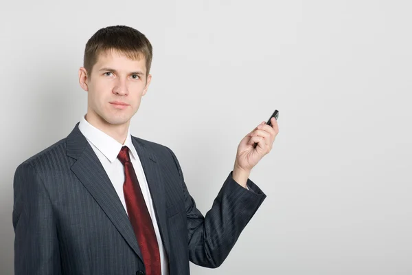 Businessman points toward your mobile phone — Stock Photo, Image