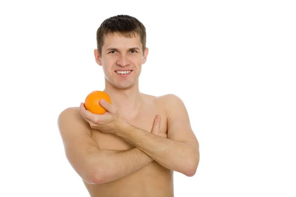 Lächelnder junger Mann mit einer Orange. — Stockfoto