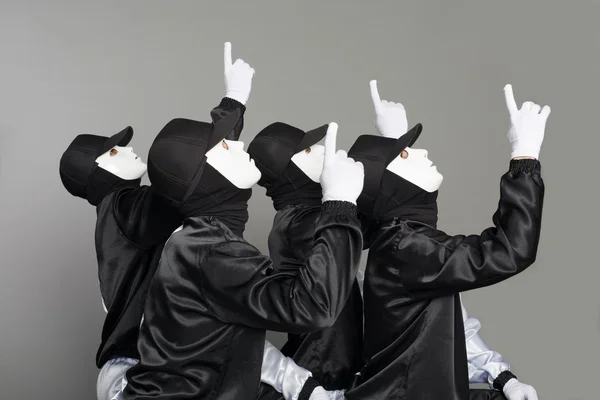 Team av unga killar i masker som pekar uppåt — Stockfoto