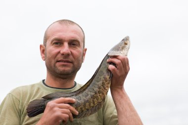 Fisherman holding a snakehead clipart