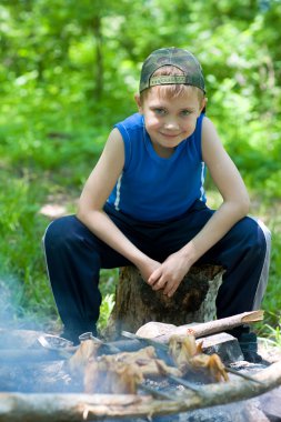 Little boy is preparing barbecue clipart