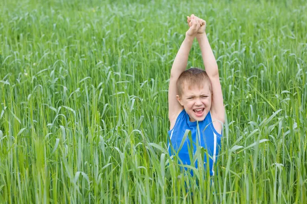 Хлопчик кричить на траві — стокове фото