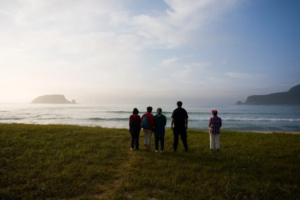 Hikers at dawn by the sea