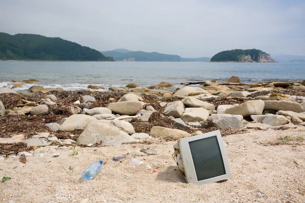 Vieux moniteurs d'ordinateur, bouteilles sur la plage . — Photo