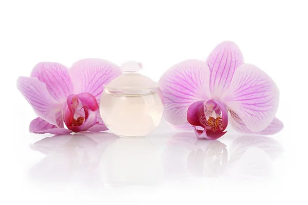 Parfüm şişesi ve orkide çiçekleri — Stok fotoğraf