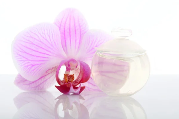 Parfümflasche und Orchideenblume — Stockfoto