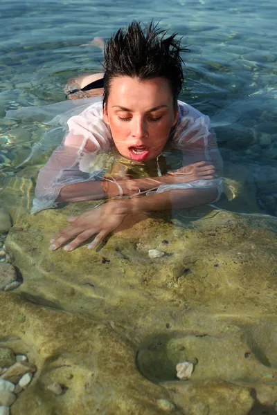 Hermosa joven tendida en el agua de mar — Foto de Stock