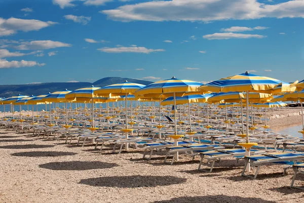 Пляж с идеально параллельными линиями зонтиков — стоковое фото