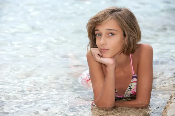 Teenagermädchen liegt im Meerwasser — Stockfoto