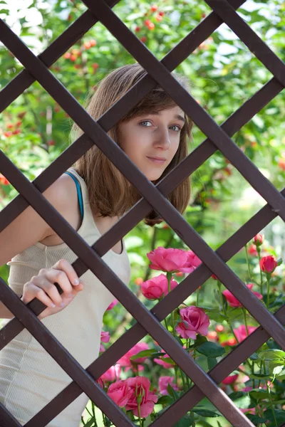 Adolescente por trás de uma cerca — Fotografia de Stock