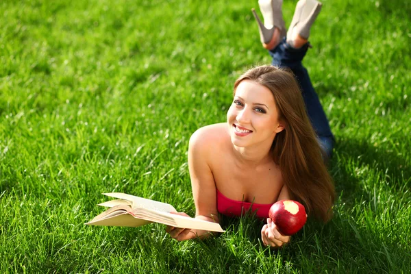 Женщина в парке с книгой — стоковое фото